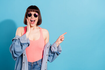 Canvas Print - Portrait of attractive cheerful amazed girl demonstrating copy space ad isolated over bright blue color background