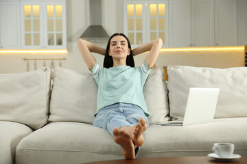 Wall Mural - Young woman relaxing on sofa at home