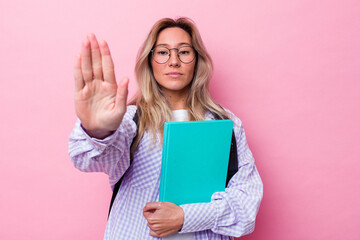 Young student australian woman isolated on pink background standing with outstretched hand showing stop sign, preventing you.