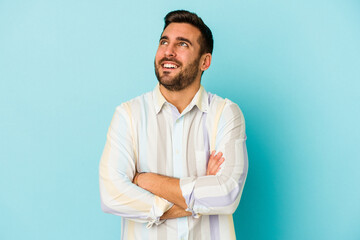 Wall Mural - Young caucasian man isolated on blue background dreaming of achieving goals and purposes