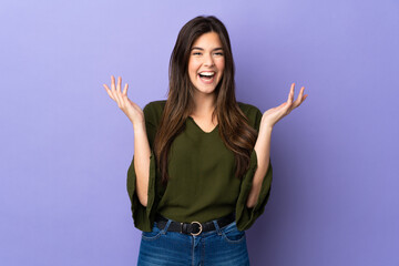 Teenager Brazilian girl over isolated purple background smiling a lot