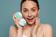 © Drobot Dean - Ginger woman wearing towel smiling while showing balls bath bomb