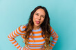 Young mexican woman isolated on blue background funny and friendly sticking out tongue.