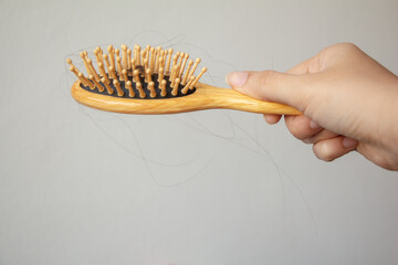 Woman honding hair loss or hair fall in comb on white background. Healthcare problem concept. 