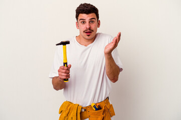 Young caucasian worker man with tools isolated on white background surprised and shocked.