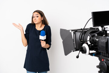 Reporter woman holding a microphone and reporting news isolated on white background making doubts gesture