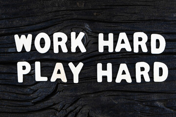 Wall Mural - Work Hard Play Hard words on dark wooden background. Business, motivational and inspirational concept.