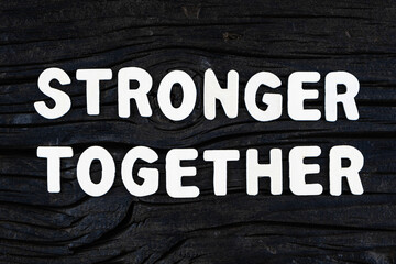 Wall Mural - Stronger Together words on dark wooden background. Business, motivational and stronger together concept.