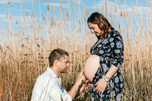 Beautiful Young Couple Expecting A Baby. Outdoor Photo Of Happy Parents To Be.