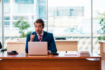 Young handsome employee working in the office