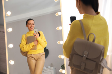 Poster - Young woman taking mirror selfie in stylish outfit at home. Morning routine