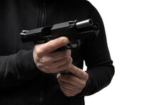 A Man In Dark Clothes Holds A Pistol In His Hands And Reloads It. Unloaded Weapon In Hand.