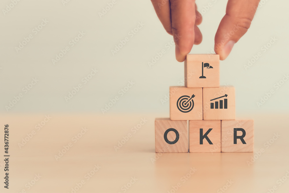 OKR text (Objectives, Key and Results) wooden cube blocks on blue background. Business target and drive business and performance. Focus on goal. Achieve business growth by flexible management - obrazy, fototapety, plakaty 