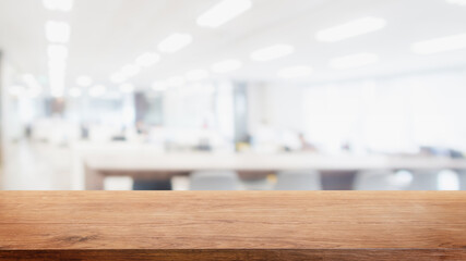 Empty wood table top and blur modern office space building background - can used for display or montage your products.