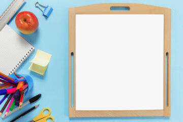 Flat lay with school concept on blue background with accessories, white board