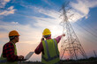 © เลิศลักษณ์ ทิพชัย - Picture of two electrical engineers checking electrical work using a computer standing at a power station to see the planning work at high voltage electrodes.