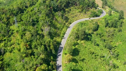 Wall Mural - Aerial view of the road in a mountain forest  Drone Shot 4K.