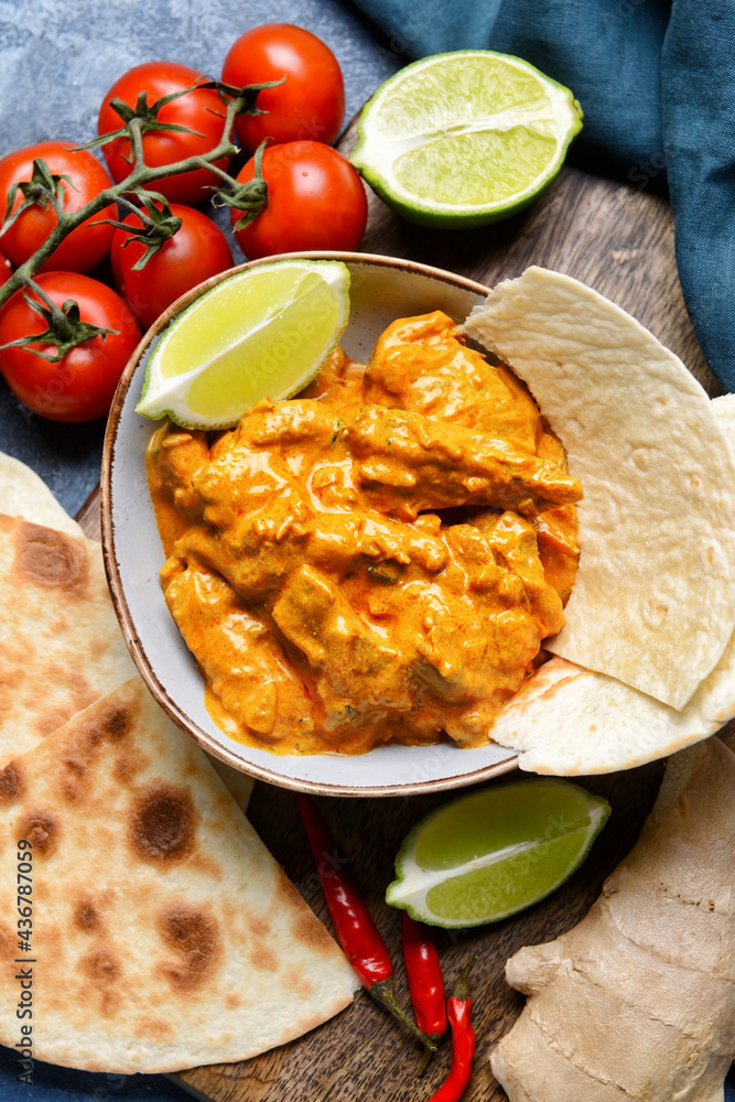 Bowl of tasty chicken tikka masala on table