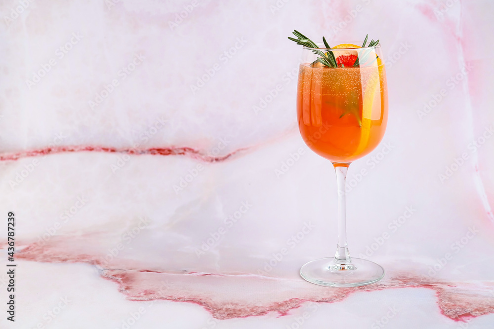 Glass of tasty grapefruit cocktail on light background