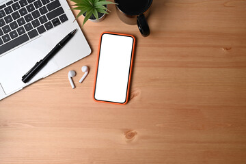 Wall Mural - top view mobile phone, laptop, coffee cup and earphone on wooden background.
