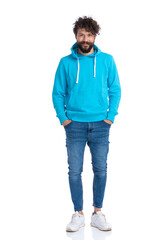 Poster - curly unshaved man with blue sweatshirt holding hands in pockets