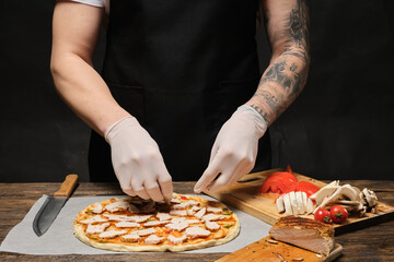 tattooed chief with the tattoo sleeve making the pizza