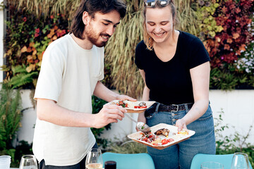 two young friends fill their plate with food at the party