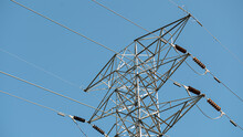 Closeup Shot Of High-voltage Powerlines Under A Clear Blue Sky