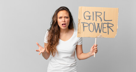 Wall Mural - young pretty woman looking angry, annoyed and frustrated and holding a girl power banner