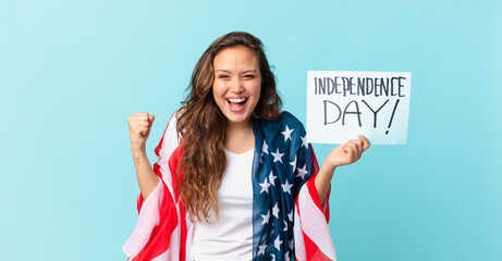 young pretty woman feeling shocked,laughing and celebrating success independence day concept