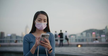 Sticker - woman wear face mask and use of mobile phone in Hong Kong city at night