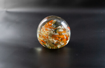 Wall Mural - closeup of a multicolor glass paperweight on a dark background