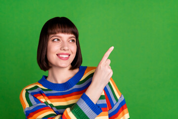 Canvas Print - Photo of positive nice happy young woman point finger empty space look smile isolated on green color background