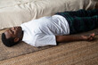 © RealPeopleStudio - Yoga. African young man meditating on a floor and lying in Shavasana pose.