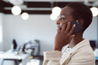 © Wavebreak Media - Smiling african american businesswoman using smartphone at work