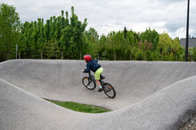 Young Boy Riding A Pump Track With Bmx Bike