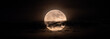 © rsimona - horizontal panoramic image of the full moon slightly obscured by clouds during the night