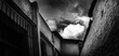 © LUCAS - Um panorama urbano em preto e branco retratando uma casa e um céu com bastantes nuvens e bem contrastadas e com texturas diferentes com a do céu, janela, telhados e paredes.
