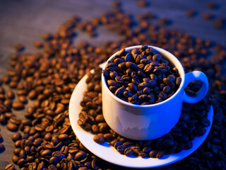 a white cup of coffee filled with roasted coffee beans. Blue backlight. For making espresso