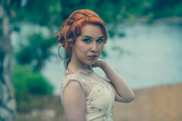 Poster - Portrait of a young caucasian female in an elegant dress outdoors