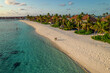© AmazingAerialAgency - Aerial view of a couple walking on the beach on a paradise island at sunset near a luxury resort on Alifu Dhaalu Atoll, Alif Alif, Maldives.