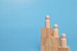 © TeacherPhoto - Wooden doll figures standing on wooden blocks. The concept of business competition