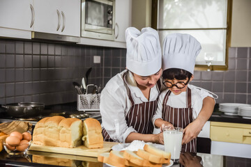 Wall Mural - Asian mother and the son cooking white flour Kneading bread dough motherteaches children practice baking ingredients bread, egg on tableware in kitchen lifestyle happy Learning life family Fun  learn