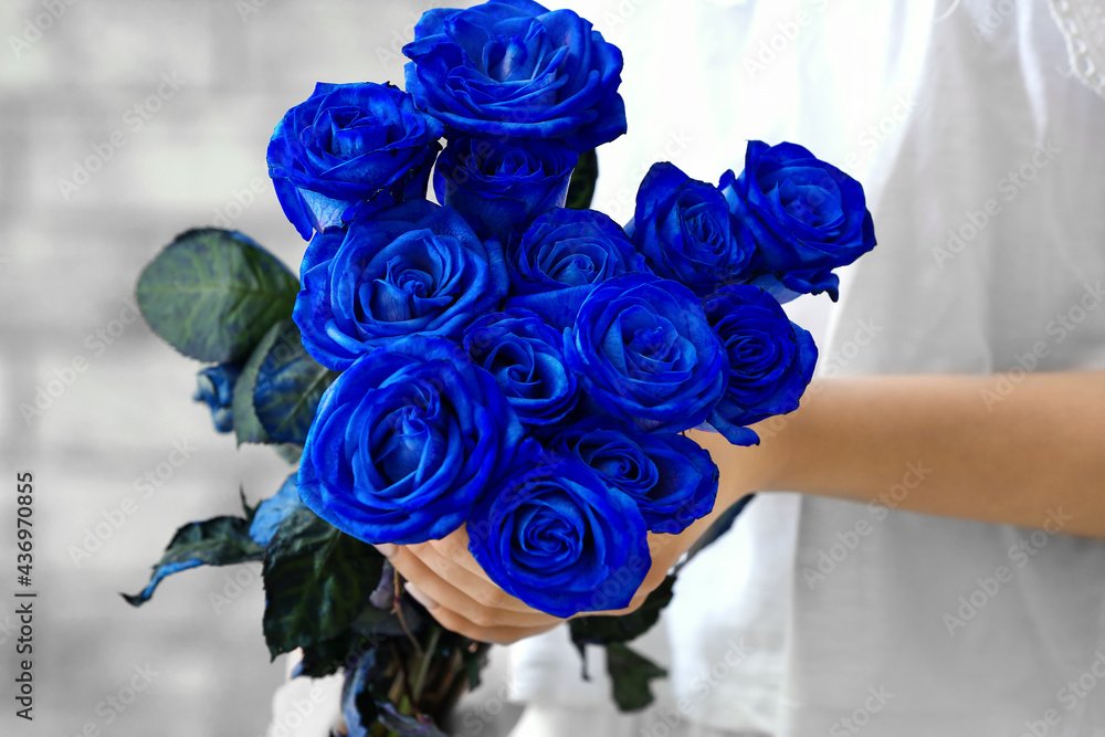 Woman with beautiful blue roses, closeup