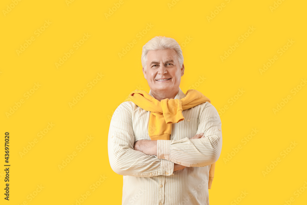 Stylish mature man on color background