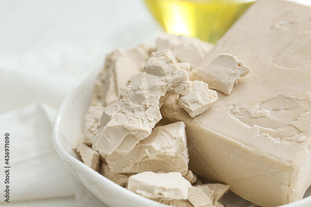 Plate with fresh yeast on light background