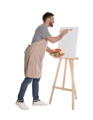 Poster - Man painting with brush on easel against white background. Young artist