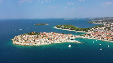 Wall Mural - Primosten town, Croatia. View of the city from the air. Seascape with beach and old town. View from drone on the peninsula with houses. Landscape during sunset. Travel video