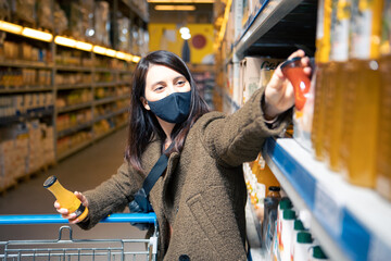 Wall Mural - woman choosing juice at grocery store