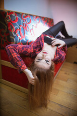 Wall Mural - Blonde Caucasian female with a red checkered shirt posing at the camera